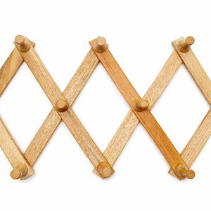 May include: A wooden accordion-style wall-mounted coat rack with multiple pegs. The rack is made of light brown wood and has a diamond-shaped design. The pegs are cylindrical and are also made of wood. The rack is designed to expand and contract.
