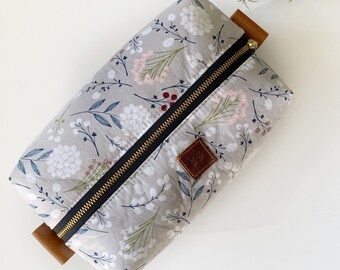 Light gray floral boxy makeup bag with turquoise interior