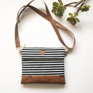 Black and white striped crossbody bag with front zipper