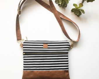 Black and white striped crossbody bag with front zipper