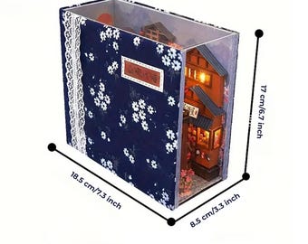 Può includere: Diorama di una casa in stile giapponese in miniatura all'interno di una scatola trasparente. La scatola misura 18,5 cm di larghezza, 17 cm di altezza e 8,5 cm di profondità. L'esterno presenta un motivo floreale blu navy e un bordo in pizzo bianco.