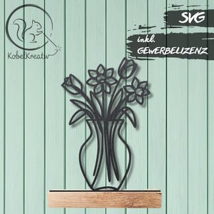 Puede incluir: Arte mural de metal negro de un jarrón con flores, incluyendo tulipanes y narcisos. La obra de arte es un diseño recortado, con el texto "SVG" y "inkl. GEWERBELIZENZ". El fondo es una pared de madera verde claro.
