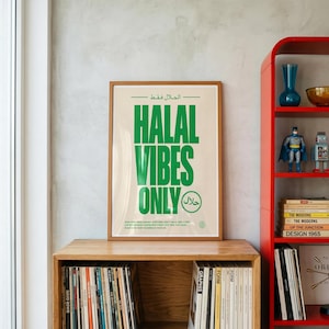 May include: A rectangular framed poster with a cream background and bold green text that reads "HALAL VIBES ONLY" in English and Arabic. The design includes smaller text at the bottom and a circular emblem featuring Arabic script.