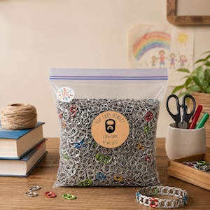 May include: A clear plastic resealable bag filled with silver aluminum soda pop tabs, featuring a round tan label that reads POP TABS DIRECT 2,500+ COUNT NET WT. 28 OZ. A small circular sticker with the text THANK YOU is on the upper left corner.