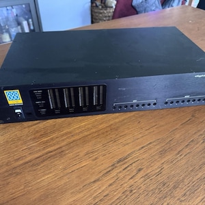 May include: A black Digidesign 888 I/O audio interface rack-mount unit featuring a yellow and blue logo, a power switch, multiple vertical LED level meters, and a series of input and output ports on the front panel with white text labels.