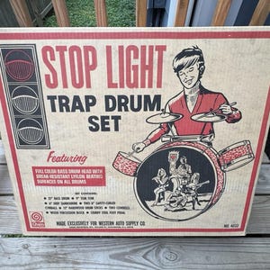 May include: Vintage "Stop Light Trap Drum Set" box. The box features a red and black design with the words "Stop Light Trap Drum Set". An illustration of a drummer playing a drum set is on the box.
