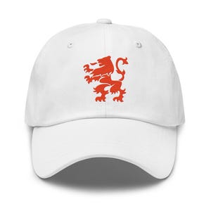 May include: A white baseball cap featuring a red lion emblem on the front. The cap has a curved brim and an adjustable strap at the back. This hat is a stylish accessory for casual wear.