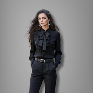 Può includere: Una camicetta nera a maniche lunghe con volant sul davanti e un grande fiocco al collo. Abbinata a pantaloni neri e una cintura nera con fibbia argentata. L'outfit è uno stile classico ed elegante.