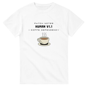 Puede incluir: Camiseta blanca con el texto "PATCH NOTES HUMAN V1.1 + COFFE DEPENDENCY" y una ilustración de una taza de café con vapor. El diseño es en negro y beige.