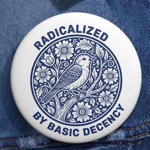 Może przedstawiać: Biała przypinka z niebieską ilustracją ptaka siedzącego na gałęzi, otoczonego kwiatami i liśćmi. Tekst "RADICALIZED" jest łukowato u góry, a "BY BASIC DECENCY" u dołu.