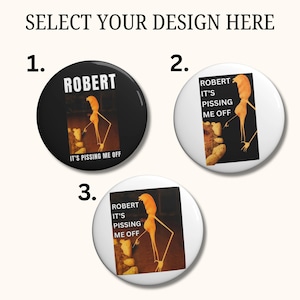 Könnte beinhalten: Drei runde Knöpfe mit dem Text "SELECT YOUR DESIGN HERE". Die Knöpfe zeigen eine Grafik einer Person mit dem Text "ROBERT IT'S PISSING ME OFF". Ein Knopf ist schwarz und zwei sind weiß.