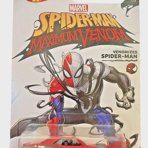May include: Hot Wheels die-cast car featuring a red Dodge with Spider-Man graphics, part of the Marvel Maximum Venom series. The packaging includes the Hot Wheels and Marvel logos, along with the text "Venomized Spider-Man".