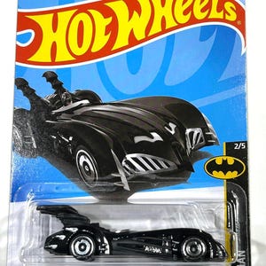 以下が含まれることがあります： ホットウィールズのバットマン＆ロビンバットモービルのダイキャストモデル。黒い車は、シルバーのアクセントとバットマンのロゴを備えた洗練されたデザインです。パッケージには、ホットウィールズのロゴ、バットマンのロゴ、および「BATMAN & ROBIN BATMOBILE」のテキストが含まれています。
