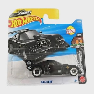 May include: A black Hot Wheels die-cast toy car, "La Liebre", on a blue and yellow card. The car has a sleek design with white wheels and the text "2026". The packaging includes the Hot Wheels Legends Tour logo.