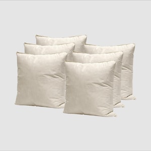 May include: A collection of six square, cream-coloured pillows. The pillows have a soft, slightly creased texture and a neutral hue. The edges of the pillows have a subtle, darker trim. These pillows are likely for home decor or bedding.