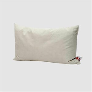 May include: A rectangular, cream-coloured pillow with a soft, puffy appearance. A tag with a Union Jack flag is attached to one corner. The pillow is designed for comfort and support.