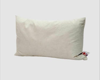 May include: A rectangular, off-white pillow with a soft, puffy appearance. The pillow has a tag with a Union Jack flag attached to one corner. The pillow is designed for comfort and support.