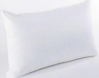 May include: A rectangular white pillow, likely for sleeping, is displayed against a white background. The pillow is fluffy and appears to be filled with a soft material. The pillow's shape is elongated, with a slight curve along its length.