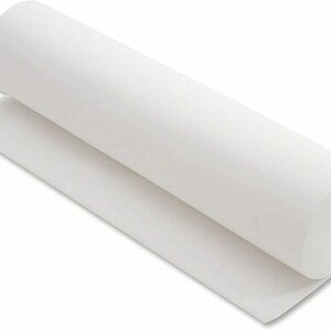 May include: A roll of white felt fabric, partially unrolled, displaying a smooth, even texture. The felt is thick and appears to be new, with a clean, bright white color. The roll is cylindrical, and the unrolled portion lies flat.