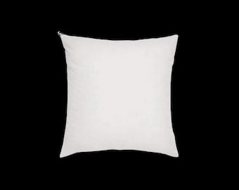 May include: A square, white pillow against a black background. The pillow has a soft, textured appearance and a zipper closure at the top. The pillow is a neutral color and could be used for decorative or functional purposes.