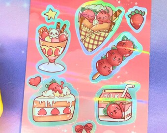 May include: A sticker sheet on a pink background featuring holographic illustrations of strawberry-themed treats including a parfait, a crepe, a skewer, a slice of cake, a milk carton, a single strawberry, a small heart, and a red bow.