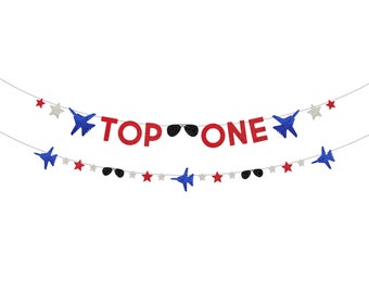 May include: A red and blue glitter banner with the words "TOP ONE" and stars and airplanes.