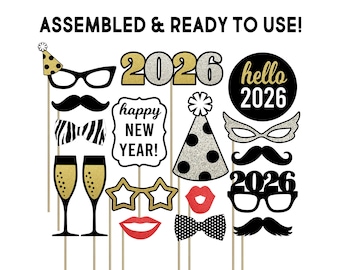 May include: A selection of New Year's Eve photo booth props, featuring glasses, moustaches, bow ties, champagne glasses, lips, and the year 2026. The props are in black, gold, and white, with the text "ASSEMBLED & READY TO USE!" and "happy NEW YEAR!"