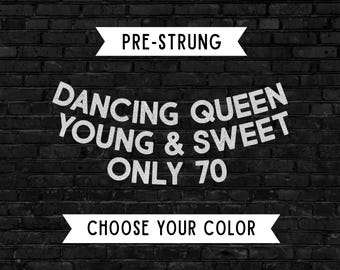 May include: A graphic design featuring white text on a black brick background. The text reads PRE-STRUNG at the top, DANCING QUEEN YOUNG & SWEET ONLY 70 in the center, and CHOOSE YOUR COLOR at the bottom. The text is arranged in a banner style.