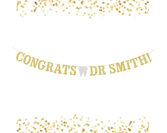 May include: Gold glitter banner with the text "Congrats Dr Smith!" and a white glitter tooth in the middle.