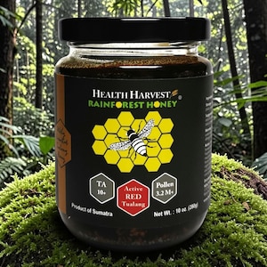 May include: A jar of Health Harvest Rainforest Honey, with a black lid and label. The label features a honeycomb design with a bee, and text indicating the product is from Sumatra, with a net weight of 10 oz (280g).