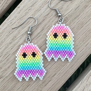May include: Rainbow beaded ghost earrings with silver hooks. The ghosts have black eyes and a white outline.