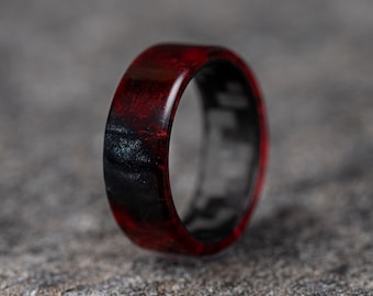 May include: A red and black ring with a carbon fiber inlay. The ring is made of resin and has a unique, marbled pattern.