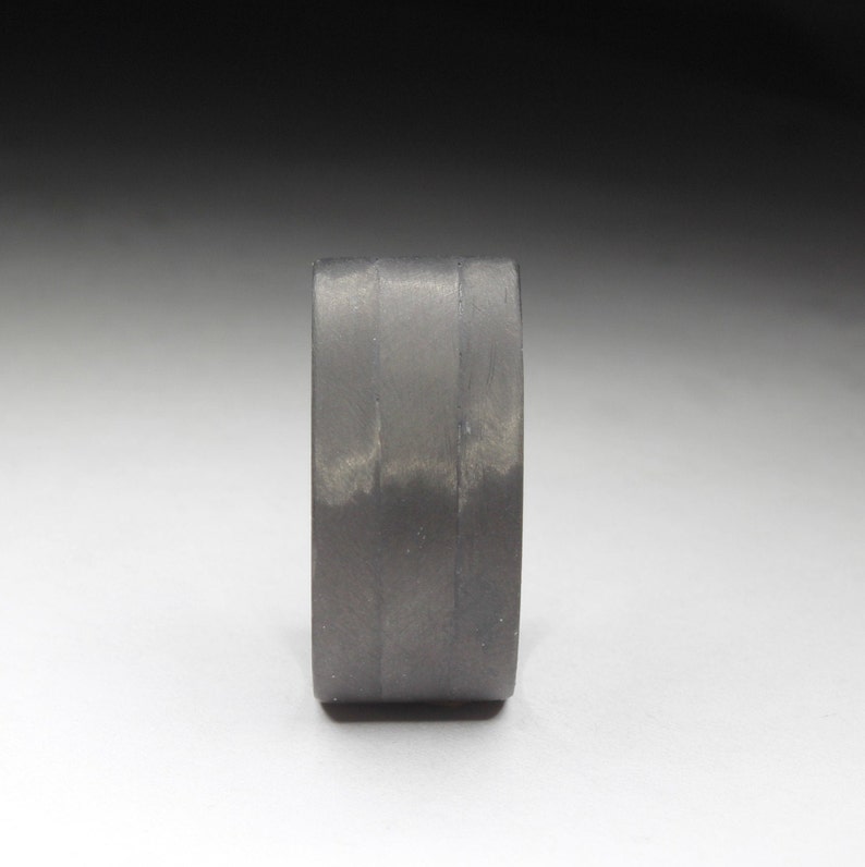 Pure Carbon Fiber ring with a Unidirectional Strip and a Blue Glow Core.