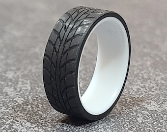 May include: A black and white tyre tread ring. The ring is made of a durable material and has a white inner band.