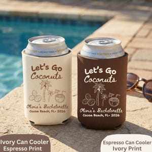 May include: Two can coolers, one ivory and one espresso, with the text "Let's Go Coconuts" and a tropical design. The text "Olivia's Bachelorette Cocoa Beach, FL. 2026" is also printed on the coolers. Perfect for a bachelorette party.