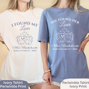 May include: Two t-shirts, one ivory and one periwinkle, with matching designs. Each shirt features the text "I FOUND MY Lover" or "SHE FOUND HER Lover", with a graphic of two cats and the text "Mia's Bachelorette, Marco Island, FL 2026."