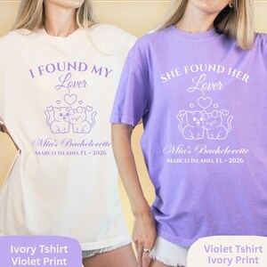 May include: Ivory and violet t-shirts with matching violet print. The shirts feature the text "I FOUND MY Lover" and "SHE FOUND HER Lover" above a graphic of two cats. The text "Mia's Bachelorette MARCO ISLAND, FL &bull; 2026" is printed below.