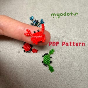 May include: A collection of beaded crab and insect designs in red, green, and iridescent blue. The red crab is the focal point, with black accents. The image includes the text "PDF Pattern" and the seller's logo.