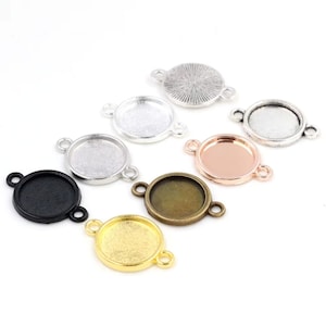 May include: A collection of round metal bezel trays in various colors, including silver, black, gold, and bronze. Each tray has two small loops for attaching to other components. The trays are designed for jewelry making and crafting.