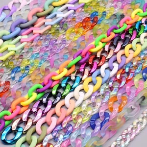 May include: A selection of brightly coloured chain links in shades of pink, purple, green, orange, and blue. The chains are made of plastic and have a glossy finish. The links are arranged diagonally, creating a vibrant and eye-catching display.