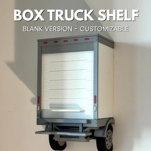 May include: A wall-mounted box truck shelf featuring a white roll-up door, gray frame, and two black wheels at the base. The text BOX TRUCK SHELF BLANK VERSION - CUSTOMIZABLE is displayed above the unit, which includes red marker lights.