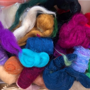 May include: A collection of loose, unspun wool roving fibers in a vibrant array of colors including magenta, deep blue, turquoise, bright orange, mustard yellow, forest green, white, and purple, all bundled together in a soft, textured pile.
