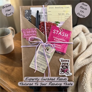 May include: A wrapped gift box with a variety of items, including a pen, tea packet, and a reading list. The box is tied with purple and white string and adorned with stickers that read "Fueled by Books & Feminine Rage" and "I love BOOKS More Than I like people."