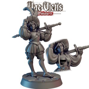 May include: A gray miniature figure of a person in Renaissance-style clothing, holding a sword. The figure wears a feathered hat, puffy sleeves, and a short skirt. A smaller, detailed version of the figure is also shown. The text "The Victis Miniatures" is at the top.
