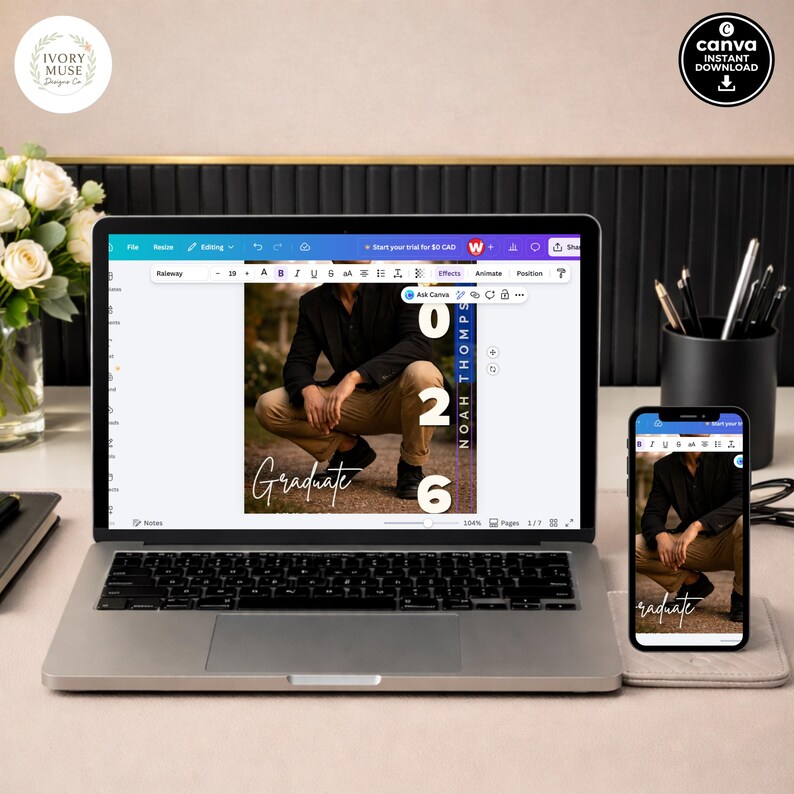May include: A laptop and smartphone display a graduation photo with the word "Graduate". The laptop screen shows a photo with the numbers "026" and the name "Noah Thompson". A black pen holder and a vase of white flowers are also visible.