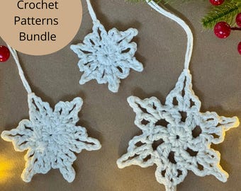 Puede incluir: Tres adornos de copos de nieve blancos de ganchillo con lazos para colgar. Los copos de nieve están dispuestos sobre una superficie marrón, con una ramita de vegetación y bayas rojas en el fondo. El texto en un círculo dice "PDF Crochet Patterns Bundle."