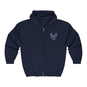 May include: Navy blue zip-up hoodie with a light blue emblem on the left chest. The hoodie features a drawstring hood and two front pockets. The zipper is silver. A comfortable, casual outerwear garment.