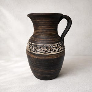 May include: A set of three ceramic mugs with a speckled, matte finish. The mugs are in shades of cream, light gray, and dark gray. Each mug has a simple, minimalist design, perfect for coffee or tea.