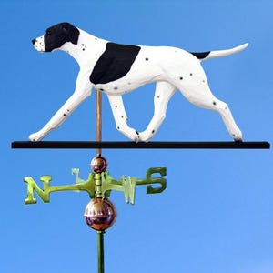 May include: A white and black dog weathervane with a copper and brass directional component. The dog has black spots and is walking on a black bar. The directional component has the letters N, S, E, and W.