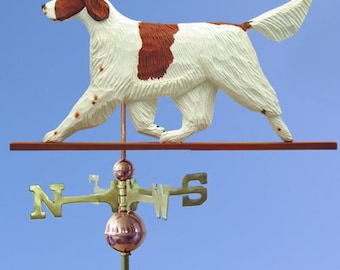 May include: A wooden weather vane featuring a white and brown Irish Red Setter dog with its tail raised. The dog is walking to the left and the vane has a traditional compass rose with the letters N, S, E, and W.
